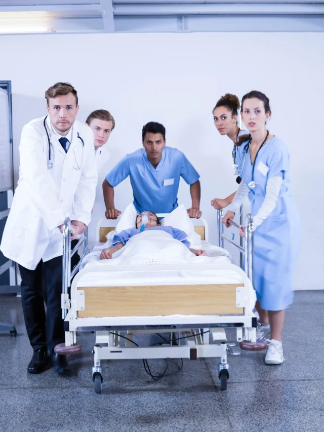 concerned-doctors-standing-near-patient-bed-hospital
